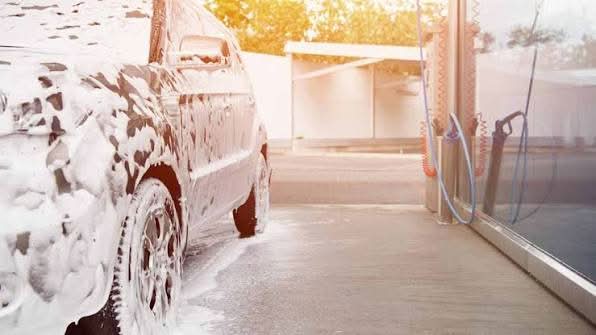 Professional carwash chemicals creating foam on a car bonnet during detailing in Melbourne